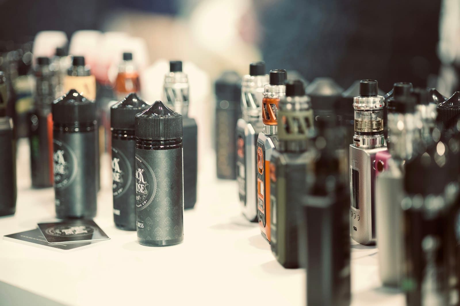 A row of Vaporesso pod mod kits and e-liquid bottles displayed on a retail counter